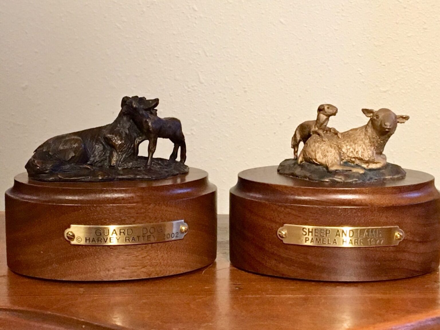 Two bronze sculptures: A guard dog with a lamb and a ewe with her lamb.