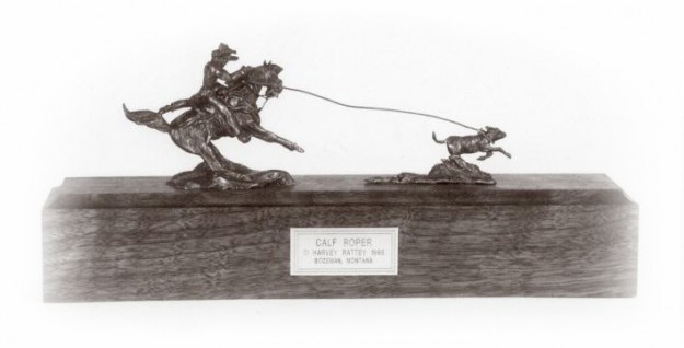 Bronze sculpture of a mounted cowboy roping a calf.