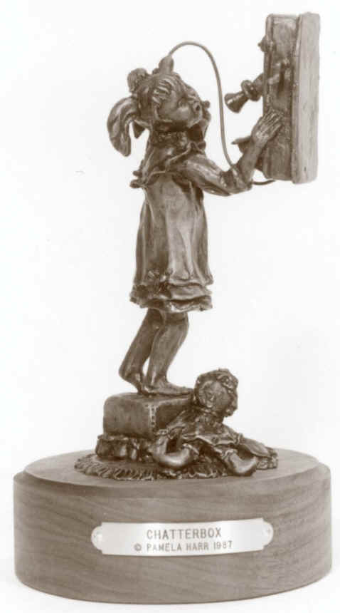 Bronze sculpture of young girl on an old telephone.