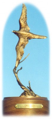 Bronze sculpture of falcon flying.