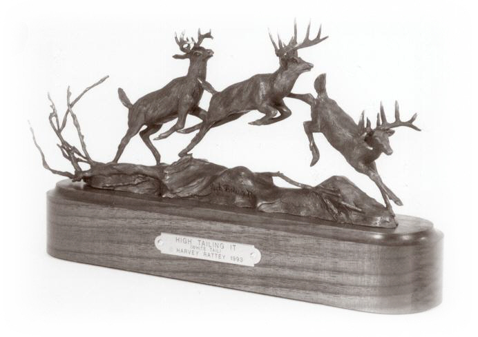 Bronze sculpture of white tail deer running.