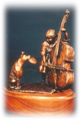 Bronze sculpture of child playing instrument and waiting dog.