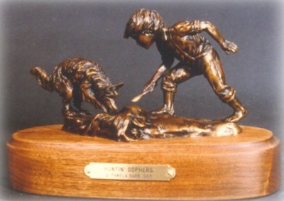 Bronze sculpture of a boy and his dog hunting gophers.
