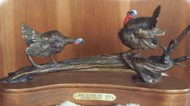 Bronze sculpture of two wild tom turkeys taking measure of one another.