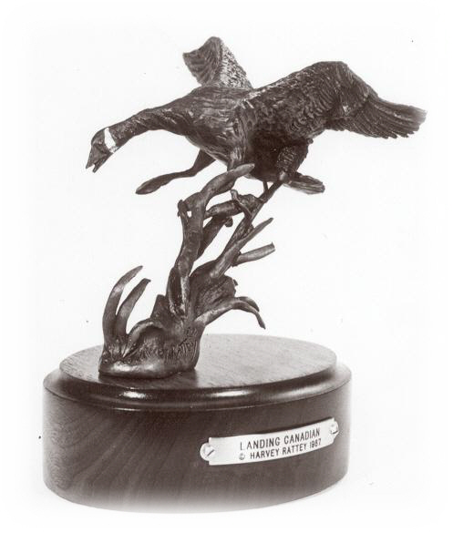 Bronze sculpture of a goose landing.