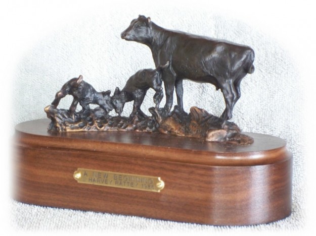 Bronze sculpture of an Angus cow and two playful calves.