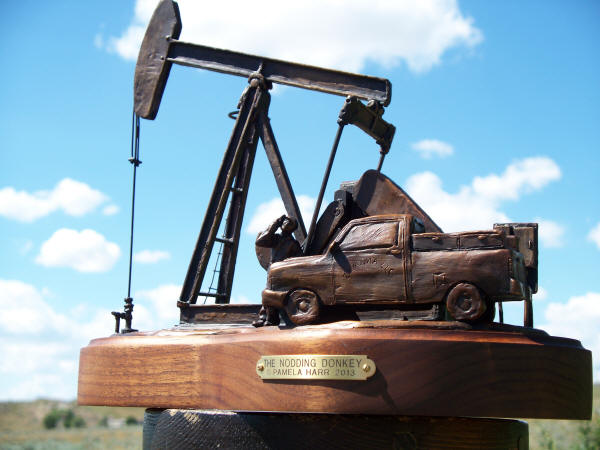 Bronze sculpture of an oil well pumping.