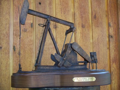 Bronze sculpture of an oil well pumping.