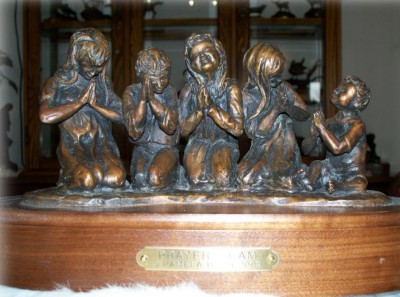 Bronze sculpture of children praying.