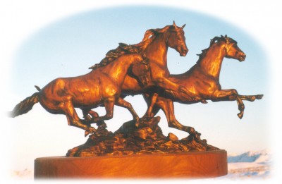 Bronze sculpture of three horses running.