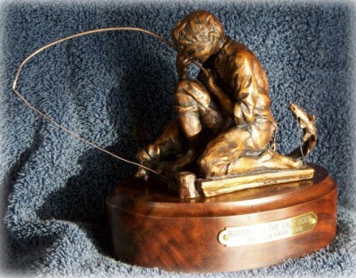 Bronze sculpture of child fishing.