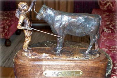 Bronze sculpture of a young girl and her her show heifer.