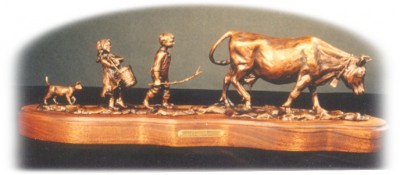 Bronze sculpture of the kids bringing in the milk cow.