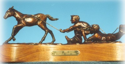 Bronze sculpture of children and colt playing.