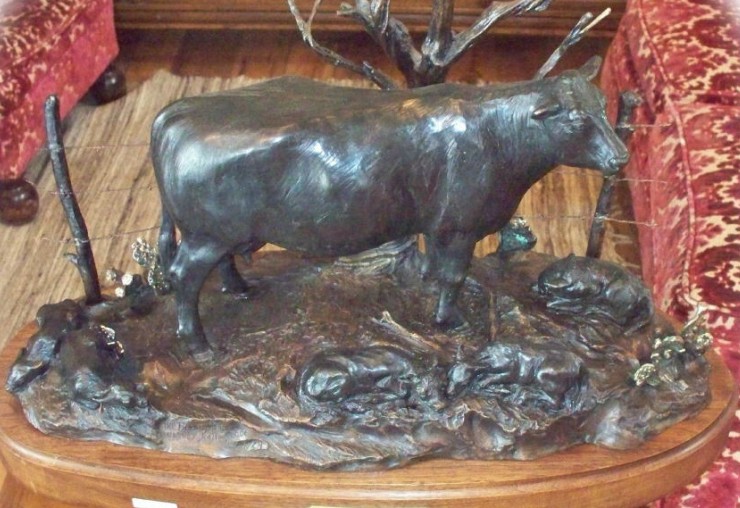 Bronze sculpture of Angus cow and five young calves.