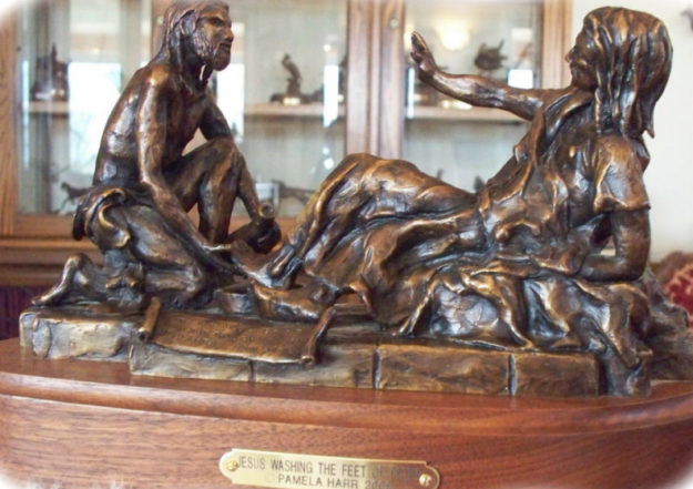 Bronze sculpture of Jesus washing Peter's feet.