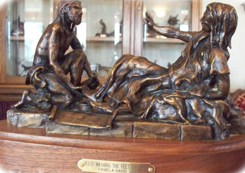 Bronze sculpture of Jesus washing Peter's feet.