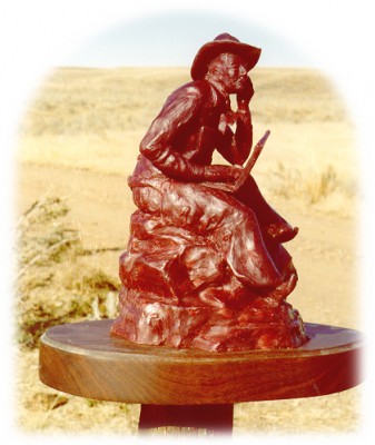 Bronze sculpture of a cowboy and his laptop.