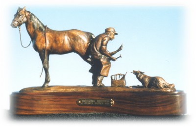 Bronze sculpture of a farrier working on a horse while his dog watches.