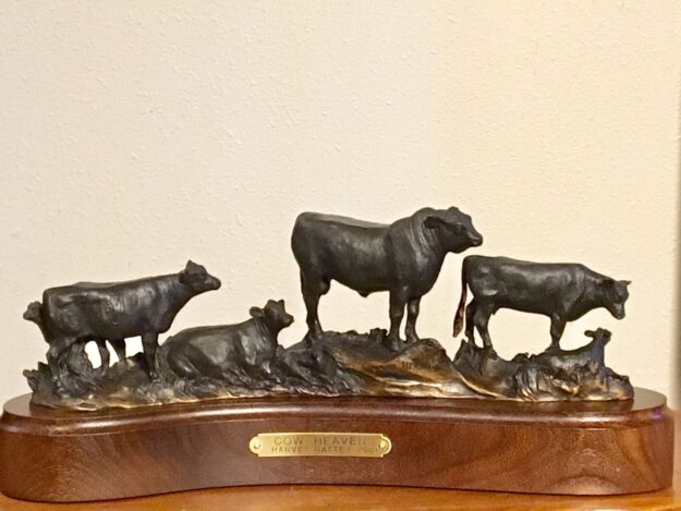 A bronze sculpture of an angus bull with cows.