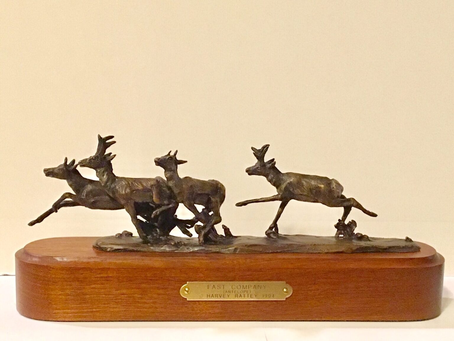 Bronze sculpture of four pronghorn racing across the prairie.