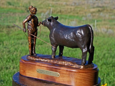 Bronze sculpture of a young teenager and her Angus steer.
