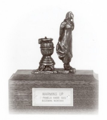 Bronze sculpture of a girl warming up at a wood stove.