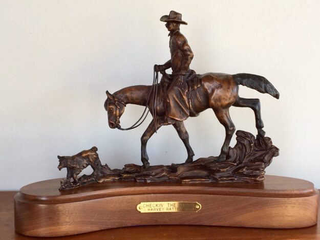 Bronze sculpture of a cowboy on his horse following his faithful dog down the trail.