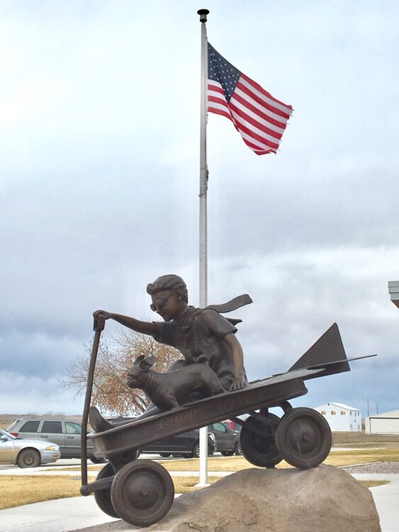 Radio Flyer, a sculpture of a small boy, his dog, and a Radio Flyer wagon.