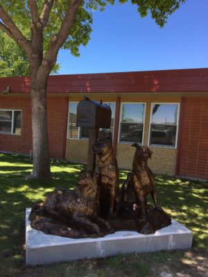Sculpture of kids and dogs waiting for the school bus