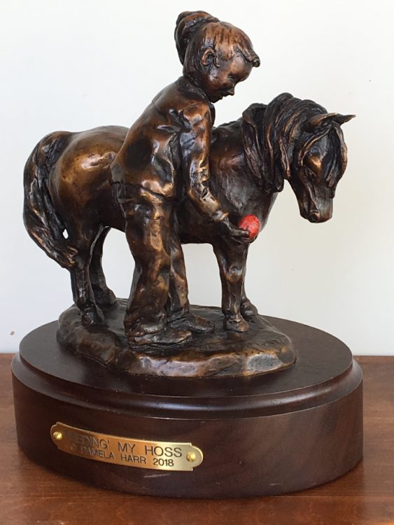 Bronze sculpture of girl feeding her pony