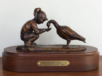 bronze sculpture of girl feeding a goose