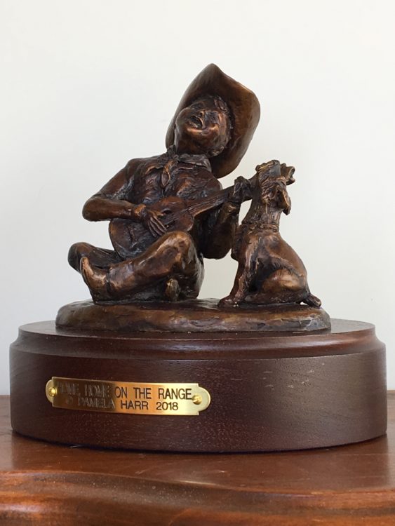 bronze sculpture of boy playing guitar with his dog