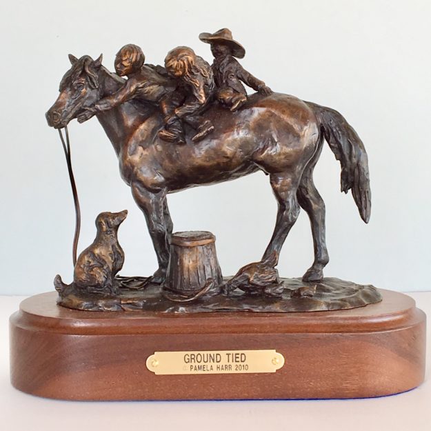 Bronze sculpture of three kids on a horse