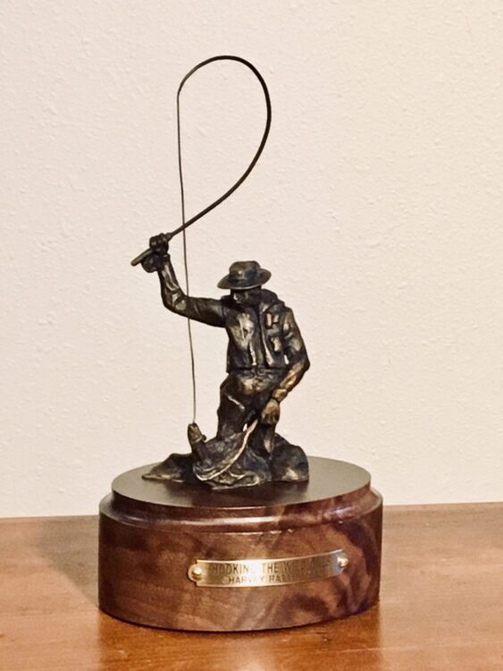 Bronze sculpture of a fly fisherman.