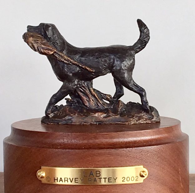 Bronze sculpture of a Labrador Retriever proudly bringing a bird back to his master.