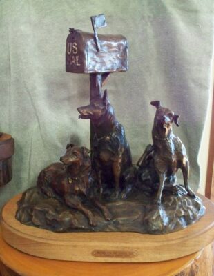 Large bronze of three dogs waiting by the mailbox