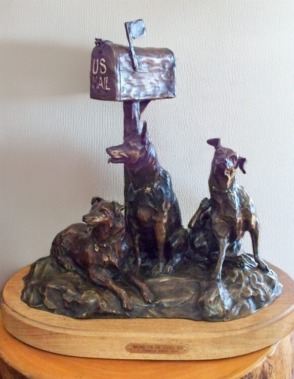 Large bronze of three dogs waiting by the mailbox