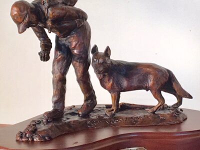 Bronze sculpture of a boy and his dog hunting for moss agates.