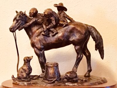Bronze sculpture of three children riding a horse bareback