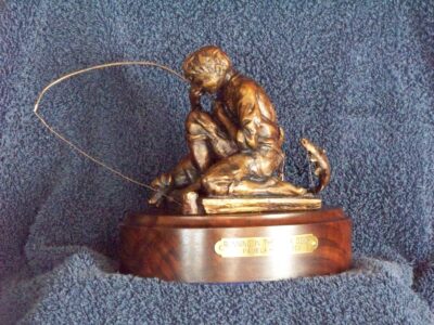 bronze sculpture of a little boy fishing