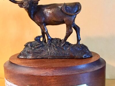 Small bronze sculpture of a longhorn cow and her newborn calf.