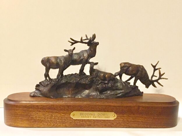 Bronze sculpture of four elk preparing to bed down for a rest.