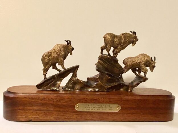 bronze sculpture of three mountain goats on the rocks.