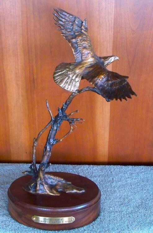 Bronze sculpture of an eagle taking off into the sky.