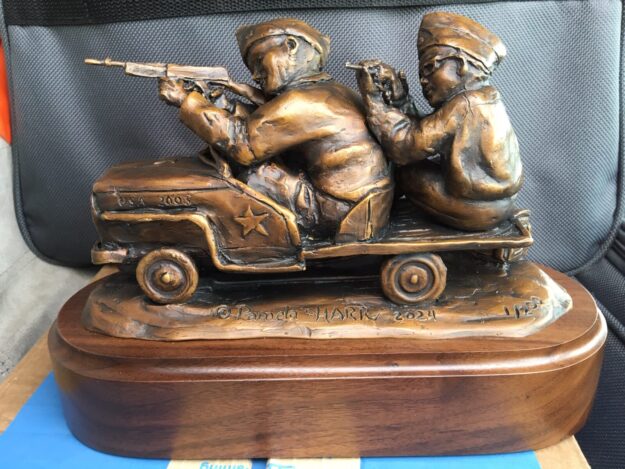 Bronze sculpture of two little boys dressed up as soldiers with a pedal Jeep and toy guns.