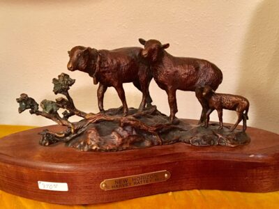 Bronze sculpture of two ewes and a lamb on their way across the range.