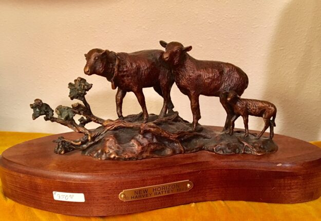 Bronze sculpture of two ewes and a lamb on their way across the range.