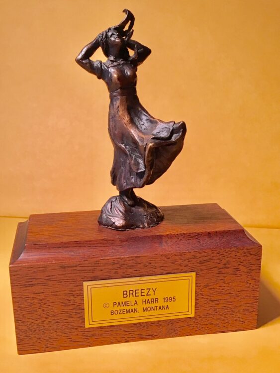 Bronze sculpture of a girl whose skirt is blowing in the wind.