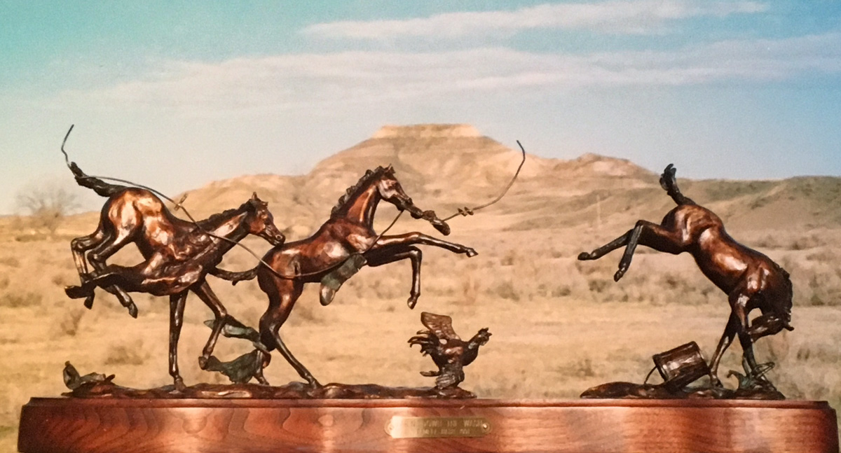 Bronze sculpture of young horses bucking and playing.